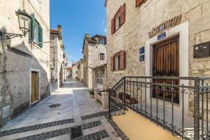 an alley in an old town with a balcony at Guesthouse Mirula in Split