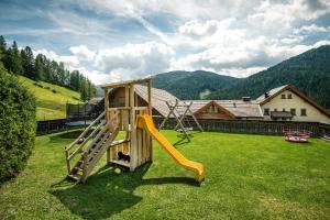 un parque infantil con un tobogán en un patio en Taela Apartments, en San Cassiano