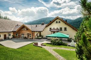 a house with a green tent in the yard at Taela Apartments in San Cassiano