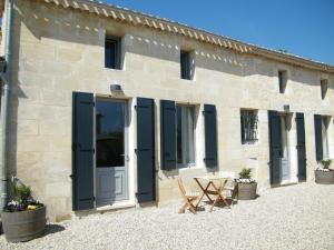 a stone building with black doors and a picnic table at Clos Vieux Rochers Vineyard in Puisseguin