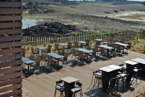 a bunch of tables and chairs on a deck at Best Western Plus Les Terrasses de Bréhat in Ploubazlanec
