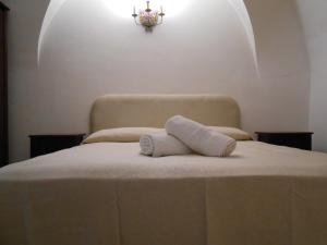パンテレリアにあるdammuso kuddiaのシャンデリア付きのベッドの上に置かれた白いタオル