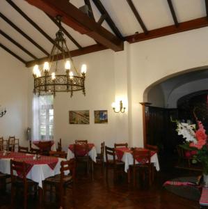 a dining room with tables and chairs and a chandelier at Centro Vacacional Huaychulo in Concepción