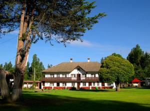 a large house sitting on top of a lush green field at Centro Vacacional Huaychulo in Concepción