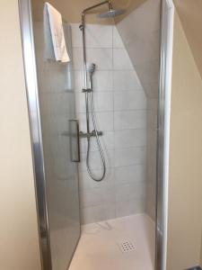 La salle de bains est pourvue d'une douche avec une porte en verre. dans l'établissement Auberge Le Meisenberg, à Châtenois