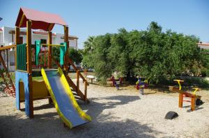 a playground with a slide in the sand at Astron Hotel in Karpathos Town