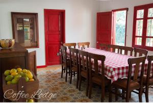 a dining room with a table and chairs and red doors at Hacienda Venecia Coffee Farm Hotel in Manizales