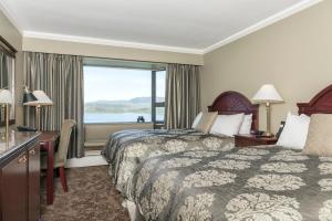 ein Hotelzimmer mit 2 Betten und einem Fenster in der Unterkunft Crest Hotel in Prince Rupert