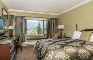 a hotel room with a bed and a window at Crest Hotel in Prince Rupert