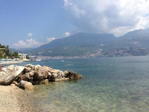 a beach with rocks and the water and mountains at Zaga Solemar Apartment in Herceg-Novi