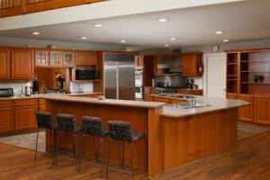 a kitchen with wooden cabinets and a island with bar stools at Muchen Villa in Delta