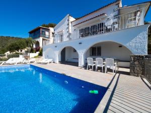 a villa with a swimming pool in front of a house at InmoSantos Casa Tordera in Roses