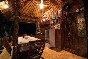 a kitchen with a refrigerator and a wooden wall at Bulian Homestay in Kubutambahan