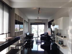 una sala de estar con sillas negras y una habitación con ventanas en Flame Tree Residence 2-Bedroom Apartment, en Hua Hin