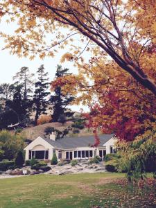 uma casa branca com árvores ao fundo em The Shan's Lodge em Queenstown