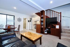 a living room with a couch and a television and a table at Fremantle Townhouse Unit 4 in Fremantle
