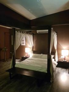 een slaapkamer met een hemelbed met 2 lampen bij Miracle Suite in Ipoh