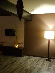 a living room with a lamp and a wall at Miracle Suite in Ipoh