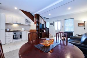 a kitchen and living room with a wooden table and chairs at Fremantle Townhouse Unit 4 in Fremantle
