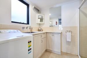 La salle de bains est pourvue d'un lavabo et d'une douche. dans l'établissement Fremantle Townhouse Unit 4, à Fremantle