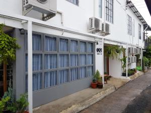- un bâtiment blanc avec de grandes fenêtres dans une rue dans l'établissement Oon Poshtel x Cafe, à Chiang Mai
