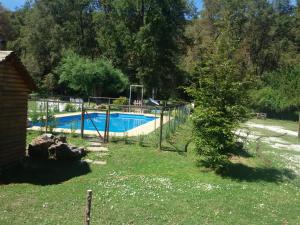 una piscina en un patio con un árbol en Cabañas Aliwen, en Las Trancas