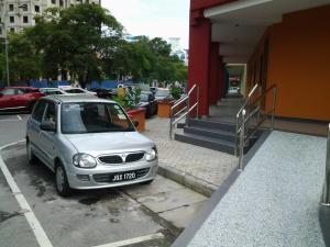 een auto geparkeerd op een parkeerplaats naast een gebouw bij Suria Seremban Hotel in Seremban