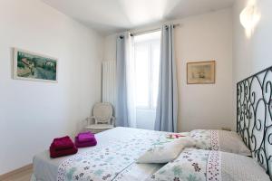 サン・レミ・ド・プロヴァンスにあるLe Moulin de St Rémy 95 m2のベッドルーム1室(紫色の枕が付いたベッド1台付)