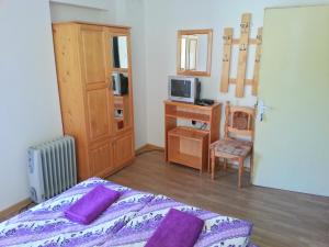 a bedroom with a bed with purple pillows and a desk at Guest House Zora in Belogradchik