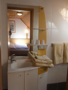 baño con lavabo, espejo y cama en Chambres d'hôtes Ruhlmann, en Dambach-la-Ville