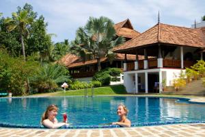 two women in the swimming pool of a resort at The Travancore Heritage Beach Resort in Kovalam