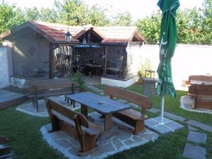 a garden with a picnic table and an umbrella at Aleksandrovo Apartments in Aleksandrovo