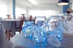 ein Tisch mit vier blauen Glasgefäßen darauf in der Unterkunft Hotel Salsedine in Rimini
