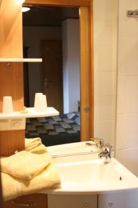 bagno con lavandino e specchio di Chambres d'hôtes Ruhlmann a Dambach-la-Ville