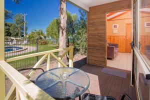 a patio with a glass table on a deck at Shepparton Holiday Park and Village in Shepparton