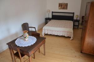 1 dormitorio con 1 cama, mesa y sillas en B&B Lacurte, en Martano
