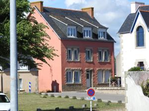 a large red and white house next to a street at La maison rouge in Le Guilvinec