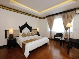 a bedroom with a large bed and a large window at Amazing Bagan Resort in Bagan