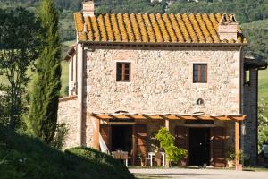 une grande maison en pierre avec un toit dans l'établissement Agriturismo Podere Campaini, à Volterra