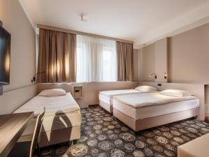 a hotel room with two beds and a table at Hotel Center Novo Mesto in Novo Mesto +38 photos