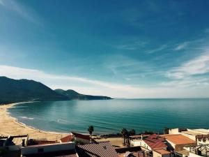 フルミニマッジョーレにあるVilla l'orto Portixeddu Sardegnaの建物と海を望むビーチの景色を望めます。