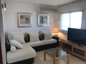 a living room with a couch and a flat screen tv at COSTA DAURADA APARTAMENTS - Zurbaran in Salou