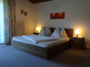 a bedroom with a bed with two lamps on it at Haus Erlbacher in Abtenau