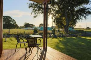 a patio with a table and chairs on a deck at Walnut Lodge B&B in Matamata
