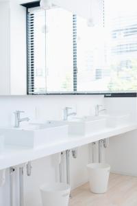 a white bathroom with two sinks and a mirror at Hatago Tenjin in Fukuoka