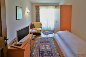 um quarto de hotel com uma cama e uma televisão em Haus Seeschwalbe em St. Wolfgang