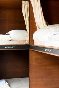 two bunk beds in a room with wooden walls at Hatago Tenjin in Fukuoka