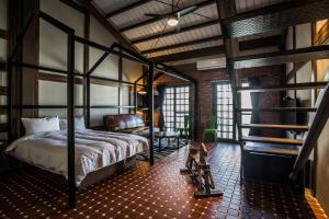 a bedroom with a four poster bed and a chair at The Brick in Tainan