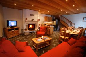 a living room with a red couch and a fireplace at Chez le Marquis du Pontet in Valloire