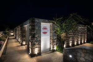 a white door with a sign on a wall at night at Melagrana in Adamas